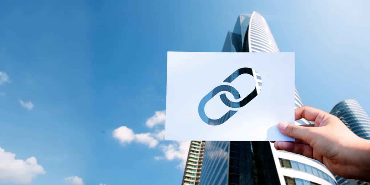 Kettenglieder-Symbol vor Hochhäusern - Verbindung internationaler Partner