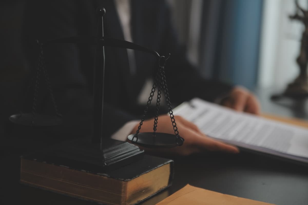 Justitia-Waage auf einem Gesetzbuch auf dem Schreibtisch der Anwaltskanzlei Lutz Färber