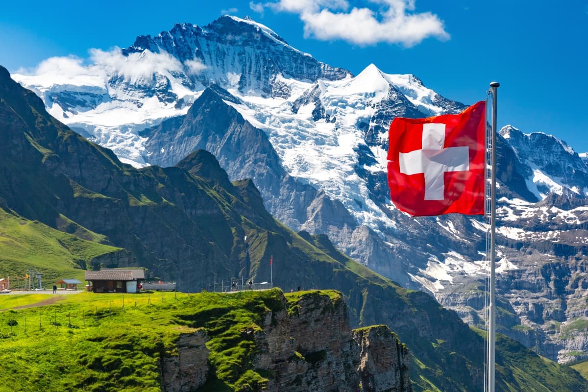 Schweizer Alpenlandschaft mit Schweizer Flagge - Symbol für den Markteintritt Schweiz