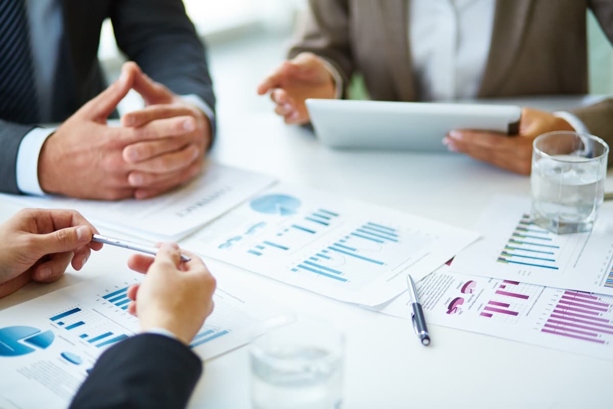 Close-up of a meeting with charts and tablet — analytical decision-making